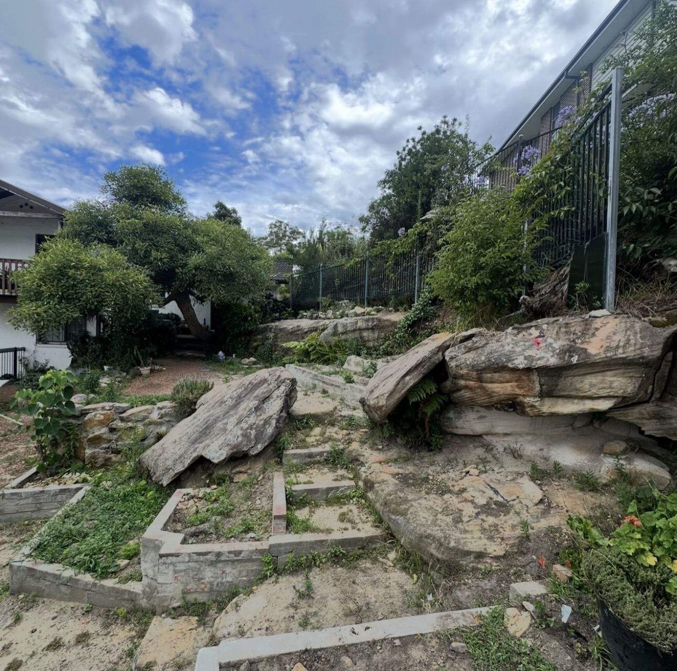 Rocky sloping backyard before rock sawing