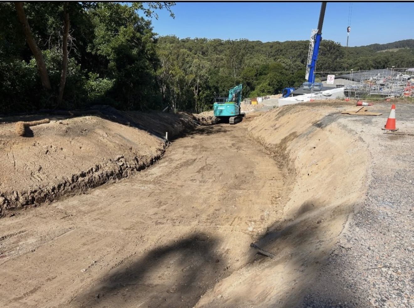 Excavator on GPS final trim of a road and batter